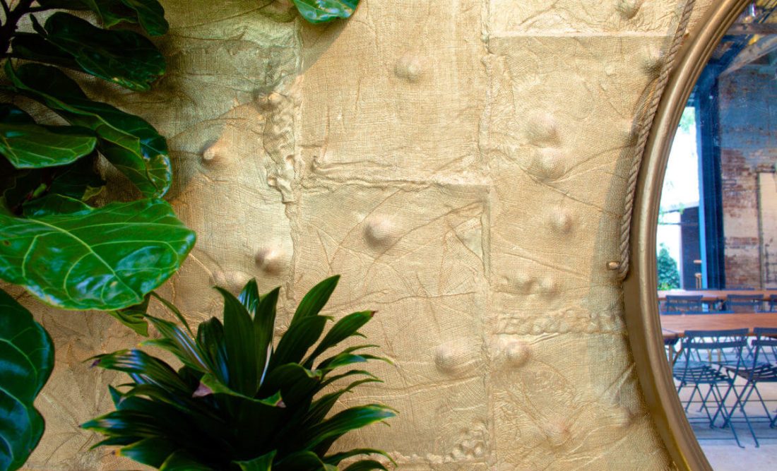 Millwick’s textured gold walls are composed of individually cast ceramic tiles hand-crafted by artist Tony Brown.